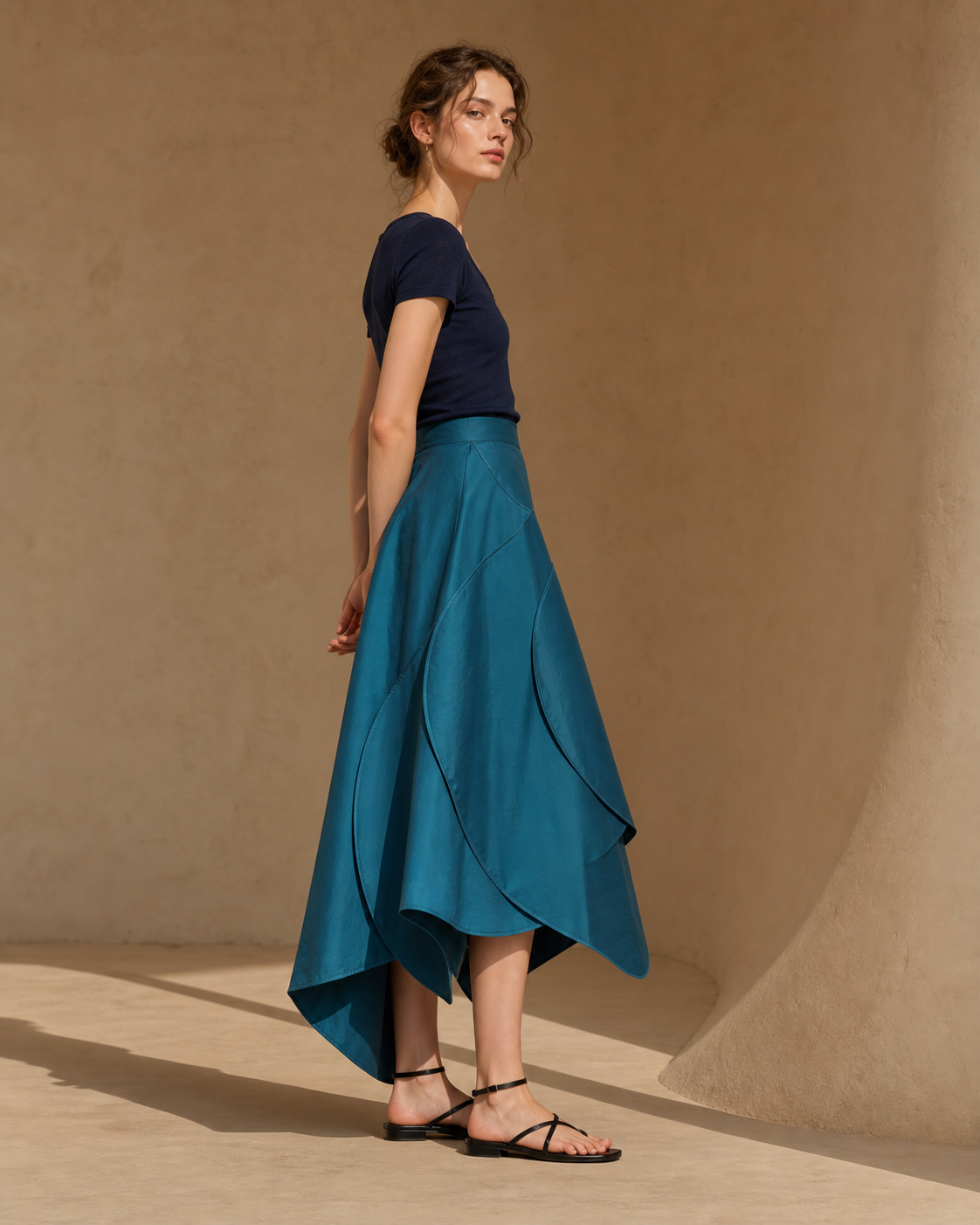 Modelo com Trace Skirt verde-azulada de costuras curvas e barra assimétrica